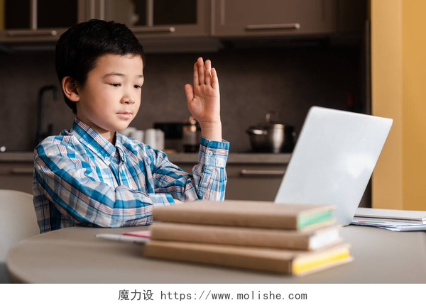 用笔记本上网课的男孩亚洲儿童在自我隔离期间，与笔记本电脑一起在网上学习